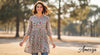 Woman wearing a stylish floral tunic and jeans, smiling outdoors – Amexza tunics for women